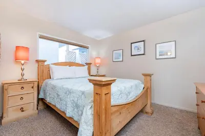 a bedroom with a wooden bed and a window at 8Br Coastal Getaway W Gorgeous Views At An Excellent Value By Beachview Rentals in Newport Beach