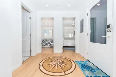 a hallway with a door and a rug on the floor at Renovated 3Br Oceanfront W Panoramic Views By Beachview Rentals in Newport Beach