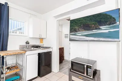a kitchen with a tv and a kitchen with the ocean at Affordable Studio, Steps From Beach And Marina Park By Beachview Rentals in Newport Beach