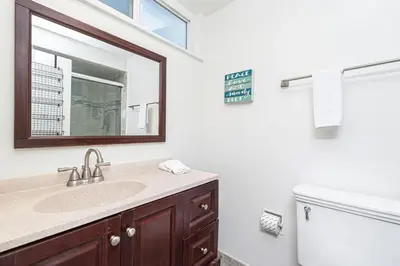 a bathroom with a sink and a mirror and a toilet at Affordable Studio, Steps From Beach And Marina Park By Beachview Rentals in Newport Beach