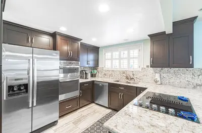 a kitchen with wooden cabinets and stainless steel appliances at Roomy 2Br W Large Patio, Fire Pit And Ocean Views By Beachview Rentals in Newport Beach