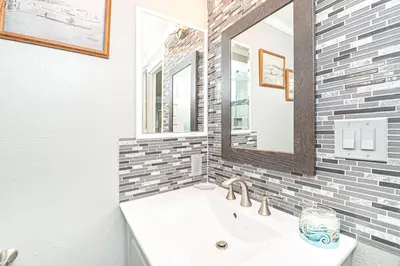 a bathroom with a sink and a mirror at Roomy 2Br W Large Patio, Fire Pit And Ocean Views By Beachview Rentals in Newport Beach