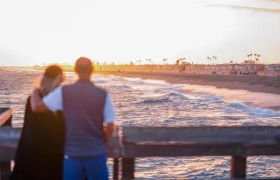 a man and a woman standing on a bench near the beach at Quiet 1Br Bayside Apartment, Central, Steps To Baybeach By Beachview Rentals in Newport Beach