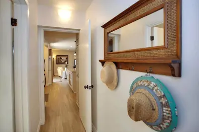 a hallway with a mirror and a hat on a wall at Quiet 1Br Bayside Apartment, Central, Steps To Baybeach By Beachview Rentals in Newport Beach