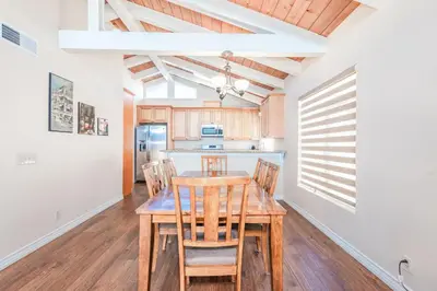 a kitchen and dining room with a wooden table and chairs at 6Br Oceanfront Duplex, Ac, Steps To Beach And Balboa Pier By Beachview Rentals in Newport Beach