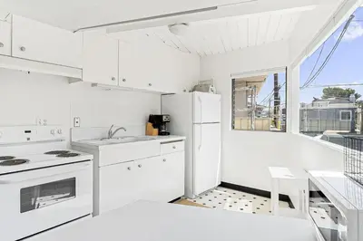 a white kitchen with white appliances and a window at Updated 1Br Bayfront Cottage W Deck In Quiet Balboa Island By Beachview Rentals in Newport Beach