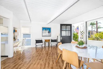 a white dining room with a table and chairs at Updated 1Br Bayfront Cottage W Deck In Quiet Balboa Island By Beachview Rentals in Newport Beach
