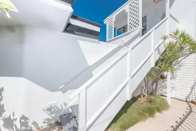 a white house with a white railing at Updated 1Br Bayfront Cottage W Deck In Quiet Balboa Island By Beachview Rentals in Newport Beach