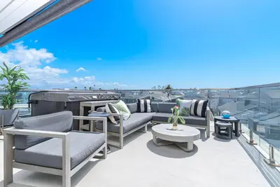 a balcony with couches and a table on a building at Luxe 3Br Near The Sand W Rooftop Spa, Ocean Views, And Ac By Beachview Rentals in Newport Beach