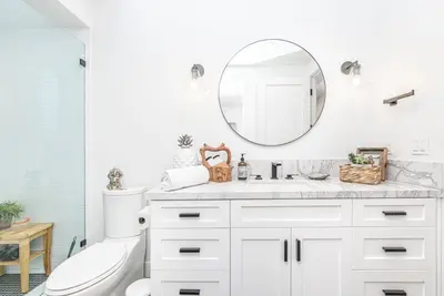 a bathroom with a white vanity and a mirror at Luxe 3Br Near The Sand W Rooftop Spa, Ocean Views, And Ac By Beachview Rentals in Newport Beach