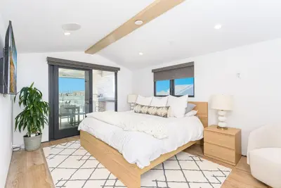 a white bedroom with a bed and a couch at Luxe 3Br Near The Sand W Rooftop Spa, Ocean Views, And Ac By Beachview Rentals in Newport Beach