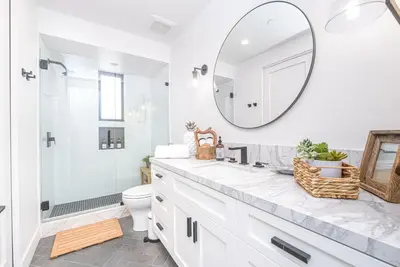 a white bathroom with a sink and a mirror at Luxe 3Br Near The Sand W Rooftop Spa, Ocean Views, And Ac By Beachview Rentals in Newport Beach