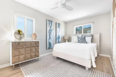 a white bedroom with a bed and two windows at Remodeled 2Br, One House From Beach, Walk To Shopsdining By Beachview Rentals in Newport Beach