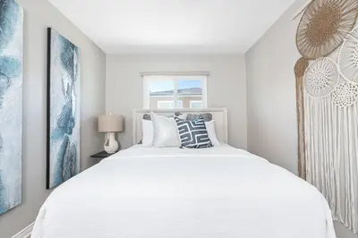 a bedroom with a white bed and a window at Remodeled 2Br, One House From Beach, Walk To Shopsdining By Beachview Rentals in Newport Beach