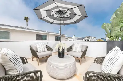 a patio with chairs and a table with an umbrella at Remodeled 2Br, One House From Beach, Walk To Shopsdining By Beachview Rentals in Newport Beach