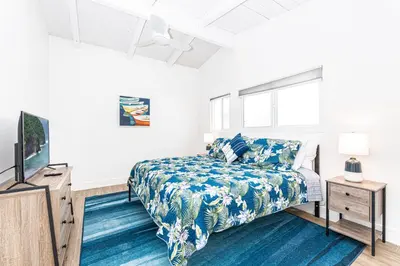 a bedroom with a bed and a flat screen tv at Stylish 2Br Cottage W Large Patio, One House From The Sand By Beachview Rentals in Newport Beach