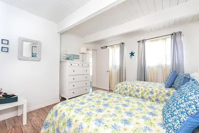 a bedroom with two beds and a dresser at Serene 3Br Bayside Home, Private Waterfront Dock And Patio By Beachview Rentals in Newport Beach