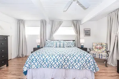 a bedroom with a bed and a chair at Serene 3Br Bayside Home, Private Waterfront Dock And Patio By Beachview Rentals in Newport Beach
