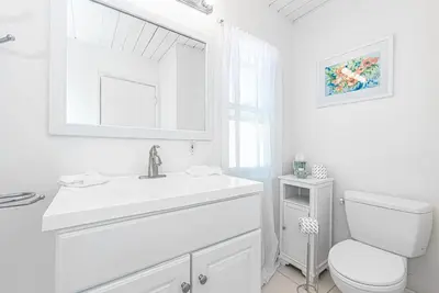 a white bathroom with a sink and a toilet at Serene 3Br Bayside Home, Private Waterfront Dock And Patio By Beachview Rentals in Newport Beach