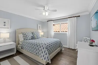 a white bedroom with a bed and a window at Elegant 6Br Oceanfront W Rooftop Deck And Stunning Views By Beachview Rentals in Newport Beach