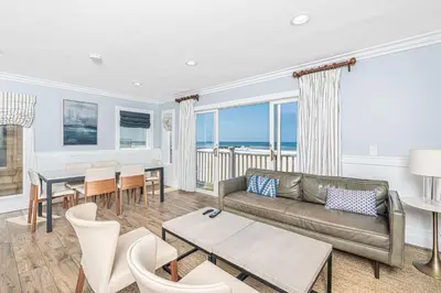 a living room with a couch and a table at Elegant 6Br Oceanfront W Rooftop Deck And Stunning Views By Beachview Rentals in Newport Beach