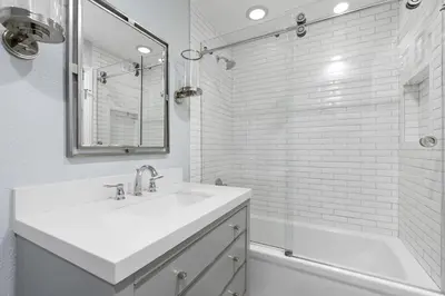 a white bathroom with a sink and a shower at Elegant 6Br Oceanfront W Rooftop Deck And Stunning Views By Beachview Rentals in Newport Beach