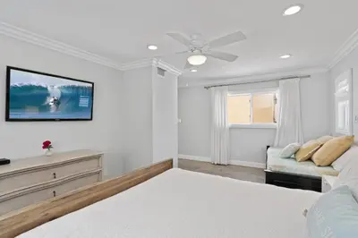a white bedroom with a bed and a couch at Elegant 6Br Oceanfront W Rooftop Deck And Stunning Views By Beachview Rentals in Newport Beach