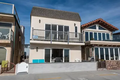 a house with a balcony on top of it at Elegant 6Br Oceanfront W Rooftop Deck And Stunning Views By Beachview Rentals in Newport Beach