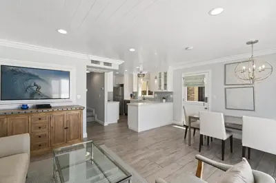 a living room with a dining table and a kitchen at Elegant 6Br Oceanfront W Rooftop Deck And Stunning Views By Beachview Rentals in Newport Beach