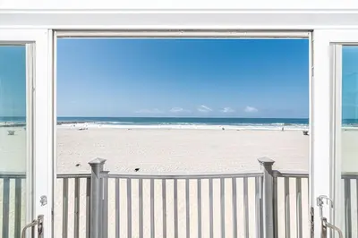 a view of the beach from the balcony of a beach house at Elegant 6Br Oceanfront W Rooftop Deck And Stunning Views By Beachview Rentals in Newport Beach