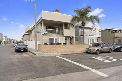 a parking lot with cars parked in front of a building at Epic 7Br Retreat W Oceanview Rooftop Deck - Steps To Sand By Beachview Rentals in Newport Beach