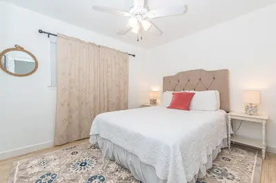 a bedroom with a white bed and a ceiling fan at Epic 7Br Retreat W Oceanview Rooftop Deck - Steps To Sand By Beachview Rentals in Newport Beach