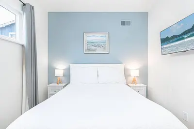 a bedroom with a white bed and two lamps at Cozy And Central 3Br, Steps From Sand And Marina Park By Beachview Rentals in Newport Beach