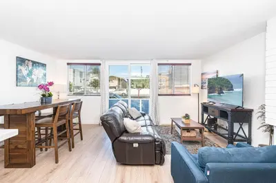 a living room with a couch and a table at Cozy And Central 3Br, Steps From Sand And Marina Park By Beachview Rentals in Newport Beach