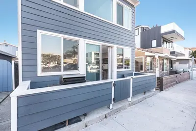 a blue house with a porch with windows at Spacious 7Br Triplex Steps From Beach And Marina Park By Beachview Rentals in Newport Beach