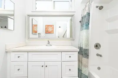 a white bathroom with a sink and a mirror at Spacious 7Br Triplex Steps From Beach And Marina Park By Beachview Rentals in Newport Beach