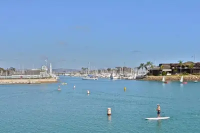 a person standing on a surfboard in the water at The Lantern House, Walk to Harbor, Great Outdoors in Dana Point
