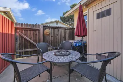 a patio with a table and chairs and an umbrella at 2 Blocks to Beach, Firepit, Sandbox, BBQ, Work in Carlsbad