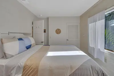a large bed in a bedroom with a large window at 2 Blocks to Beach, Firepit, Sandbox, BBQ, Work in Carlsbad
