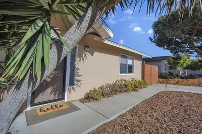 a house with a sign on the side of it at 2 Blocks to Beach, Firepit, Sandbox, BBQ, Work in Carlsbad