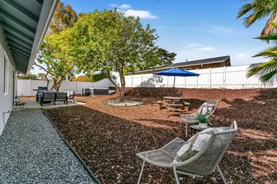 a patio with chairs and a table and an umbrella at Neat Retreat w Hot Tub Near Beach and Downtown in San Diego