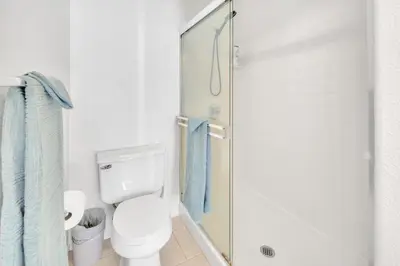 a bathroom with a toilet and a glass shower at Heart of Carmel Valley 2BR, Families and Corp Stays in San Diego