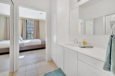 a white bathroom with a sink and a bed at Heart of Carmel Valley 2BR, Families and Corp Stays in San Diego