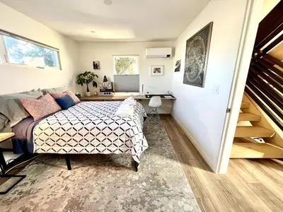 a bedroom with a bed and a stairway at Private Rooftop Retreat with Stunning City Views in San Diego