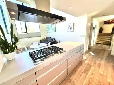 a kitchen with a stove and a living room at Private Rooftop Retreat with Stunning City Views in San Diego