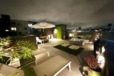 a rooftop patio at night with an umbrella and plants at Private Rooftop Retreat with Stunning City Views in San Diego