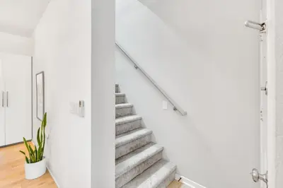a staircase in a house with white walls and white floors at Little Italy Urban Designer Loft Parking, WandD, AC in San Diego