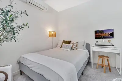 a white bedroom with a bed and a desk at Little Italy Urban Designer Loft Parking, WandD, AC in San Diego