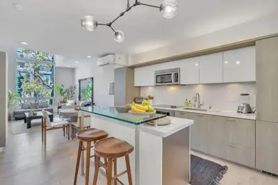 a kitchen with a island with stools and a counter top at Little Italy Urban Designer Loft Parking, WandD, AC in San Diego