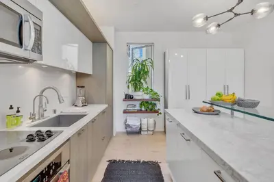 a white kitchen with a sink and a counter at Little Italy Urban Designer Loft Parking, WandD, AC in San Diego